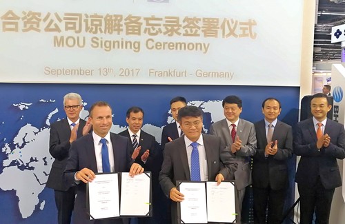 Jörg Grotendorst, Leiter der ZF-Division E-Mobility, und BHAP-Geschäftsführer Chen Bao unterzeichnen auf der IAA im Beisein von hochrangigen Vertretern der Vertragspartner die Vereinbarung für die Komponentenfertigung in China.
