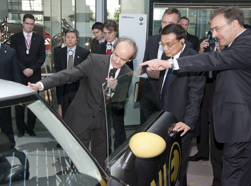 Ulrich Kranz (links), Leiter des „Project i“ zur nachhaltigen Mobilität bei BMW, und Konzernchef Dr. Norbert Reithöfer (rechts) zeigen Li Keqiang den Mini E.
