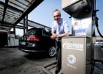 Vyacheslav Krupenkov, Hauptgeschäftsführer Gazprom Germania, betankt einen gasbetriebenen VW Passat.